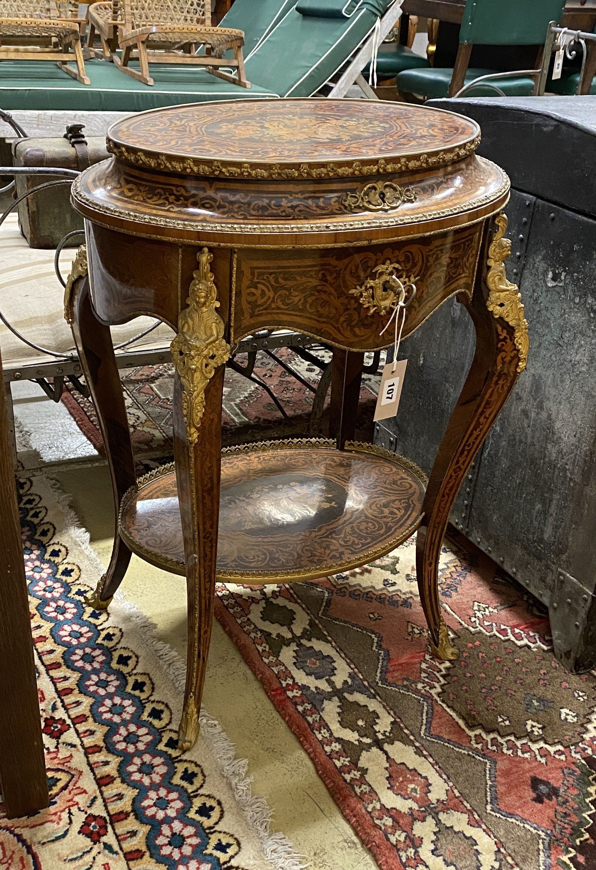 A Louis XVI style marquetry inlaid oval gilt metal mounted two tier work table, width 56cm, depth 42cm, height 78cm